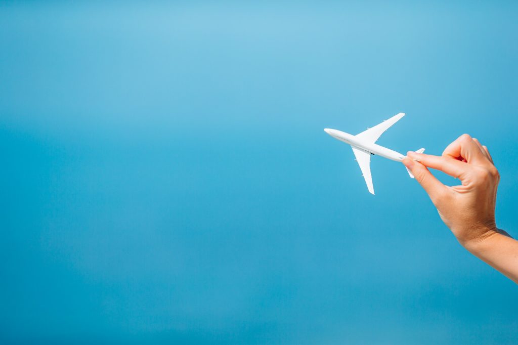 Miniature toy airplane in female hands. Trip by airplane. Conceptual image for travel and tourism
