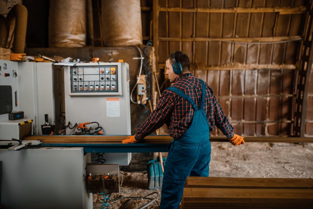 Woodworker works on machine, lumber industry